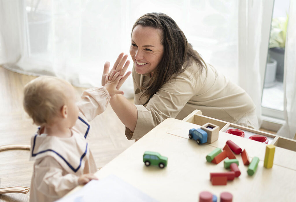 Mother and baby daughter giving high fives